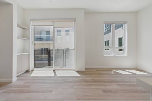 A room with a large window and a view of a building outside.