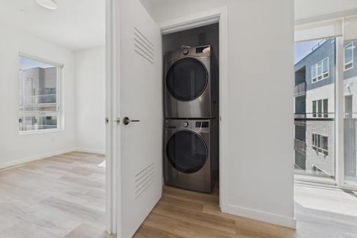 A modern laundry room with a washer and dryer in a white cabinet.