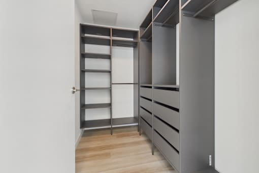 A room with a grey shelving unit and a white door.