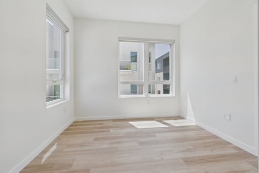 A room with a window and a wooden floor.