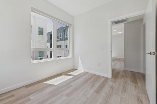 A room with a large window and wooden flooring.