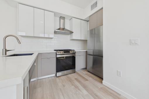 A modern kitchen with a stainless steel refrigerator and oven.