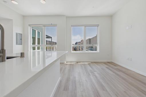 A spacious room with white walls and a large window overlooking a cityscape.
