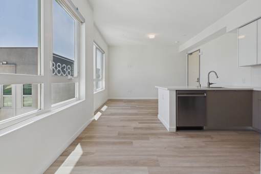 A kitchen with a white counter top and a dishwasher.