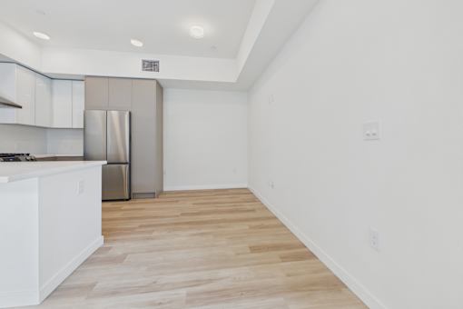 A kitchen with a refrigerator, stove, and cabinets.