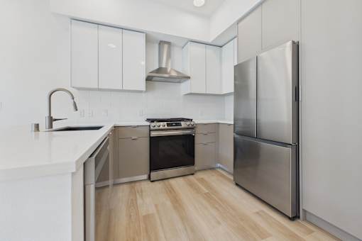 A modern kitchen with stainless steel appliances and white cabinetry.