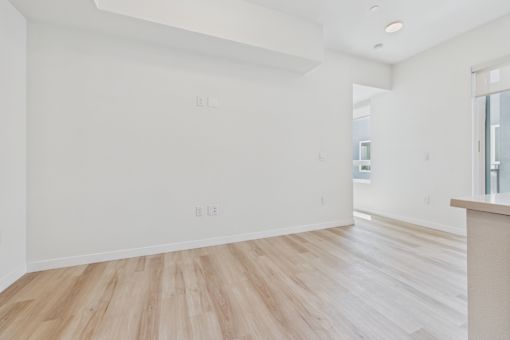 A room with wooden flooring and white walls.