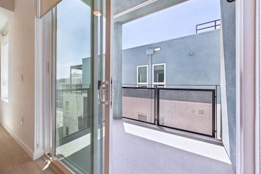 A glass door with a handle is open to a balcony.