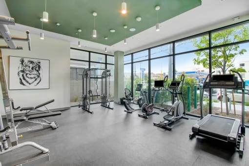 a workout room with gym equipment and large windows