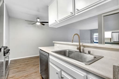 a kitchen with a sink and a ceiling fan