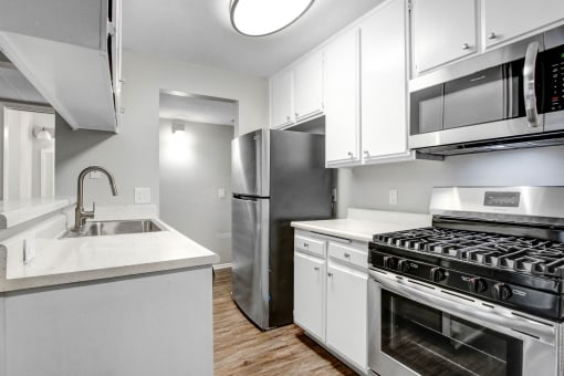 a kitchen with white cabinets and stainless steel appliances