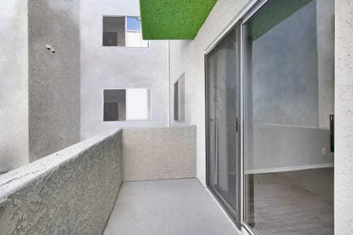 a large white room with a glass door and a balcony