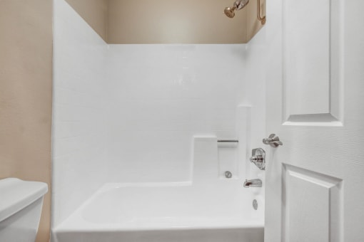 a white bathroom with a tub and a sink
