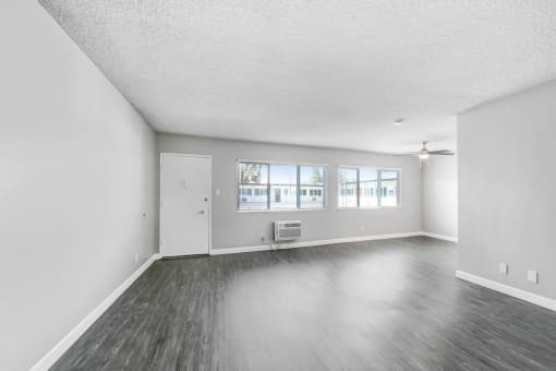 an empty living room with white walls and wood floors