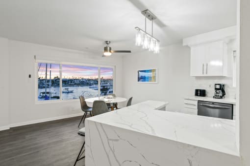 a kitchen with a marble counter top and a table with chairs