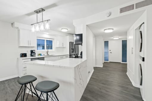 a kitchen with a bar and stools in a house