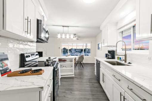 a kitchen with white cabinets and marble counter tops and a sink