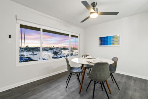 a dining room with a large window and a table and chairs