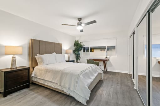 a bedroom with a bed and a ceiling fan
