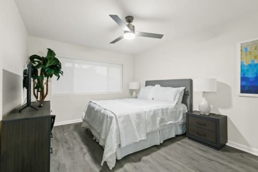 a bedroom with a large bed and a ceiling fan