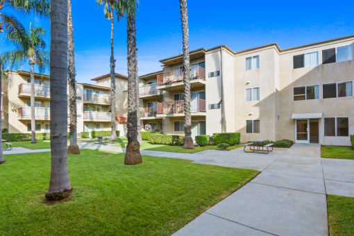 an apartment building with a courtyard and palm trees