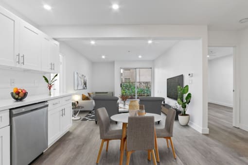 a living room and dining room with a table and chairs