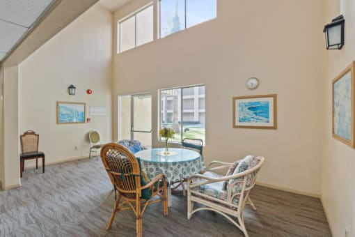 a dining room with a table and chairs and windows