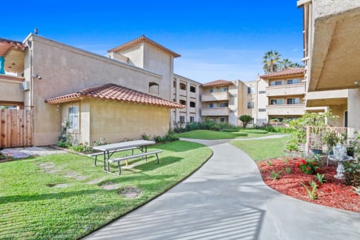 a picnic table sits on a sidewalk in front of an apartment building