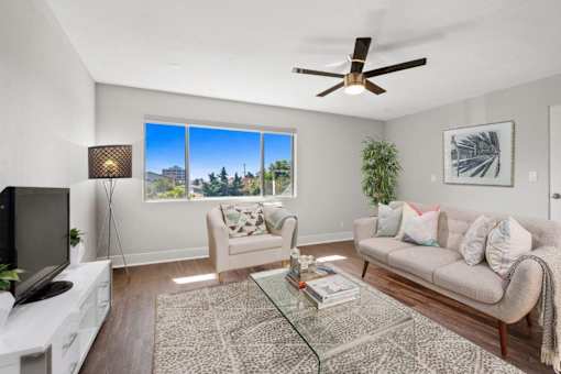 A living room with a couch, a chair, a coffee table, and a television.