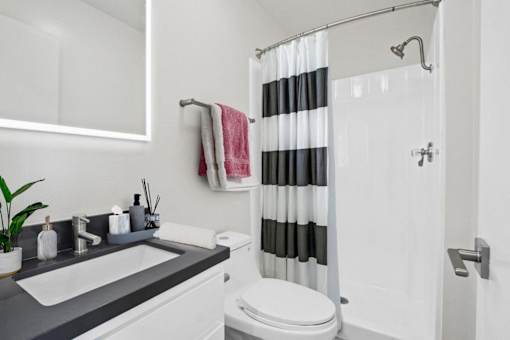 A white toilet sits next to a sink in a bathroom.