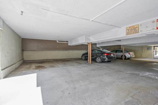 A parking garage with a white ceiling and a sign on the wall.