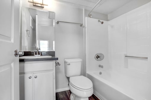 a white bathroom with a white toilet and a tub and a sink