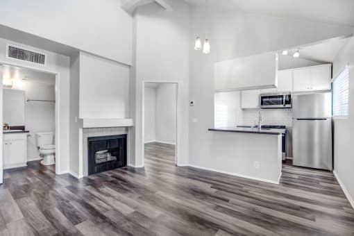 a living room with a fireplace and a kitchen