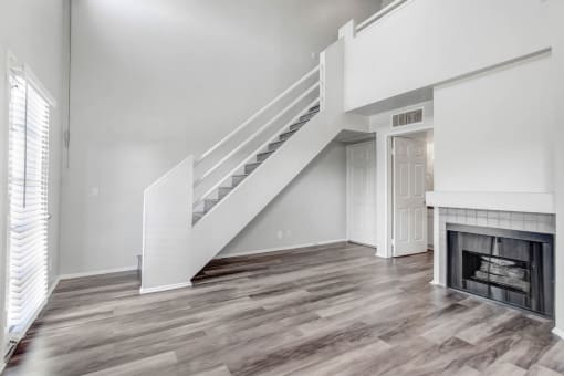 a living room with a staircase and a fireplace