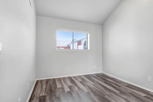 the living room of our studio apartment atrium with wood flooring and a window