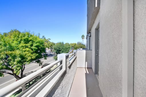 the view from the balcony of a large apartment building overlooking a city street