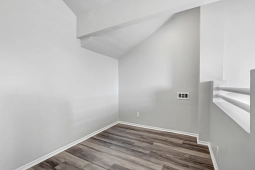 an empty room with white walls and a wooden floor