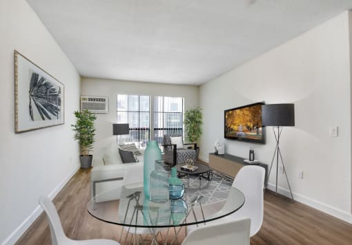a living room with a glass table and white chairs