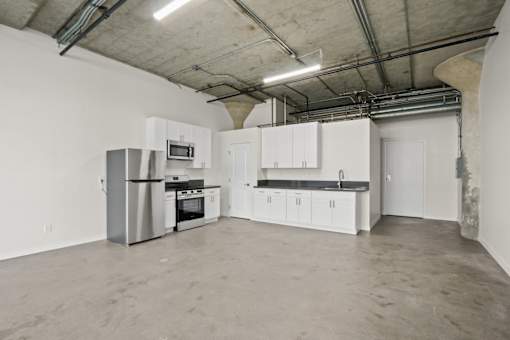 A kitchen with white cabinets and a black countertop is shown.