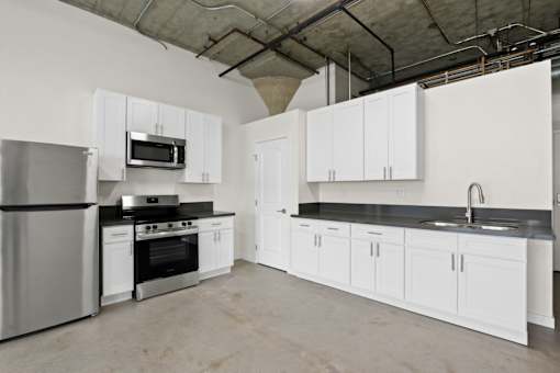 A kitchen with white cabinets and appliances.