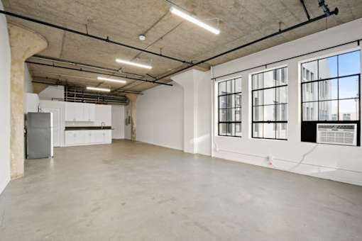 A large empty room with a concrete floor and walls.