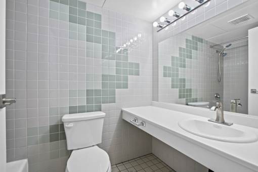 A white toilet sits next to a white sink in a bathroom.