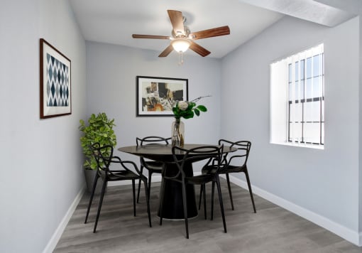 a dining room with a table and chairs and a ceiling fan