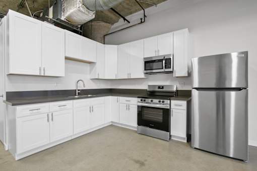 A kitchen with white cabinets and stainless steel appliances.