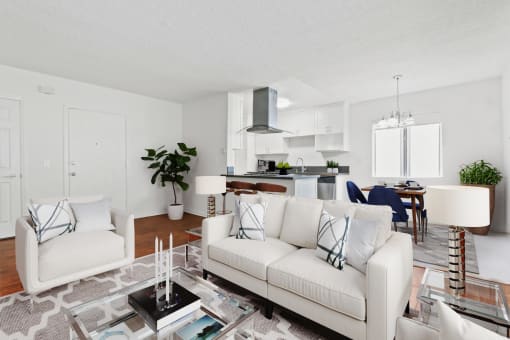 a living room with white couches and a glass coffee table