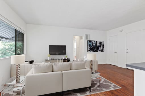 a living room with a white couch and a tv