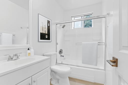 a white bathroom with a shower toilet and sink