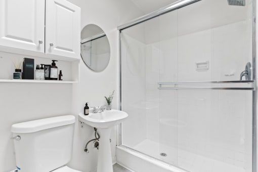 a white bathroom with a shower and a sink