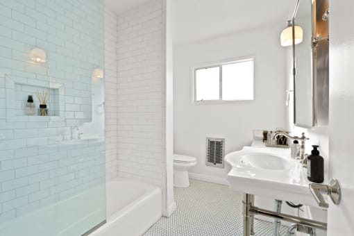 a white bathroom with a sink and a shower and a toilet