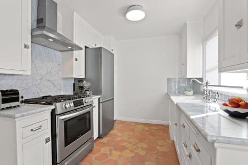 a kitchen with stainless steel appliances and white cabinets